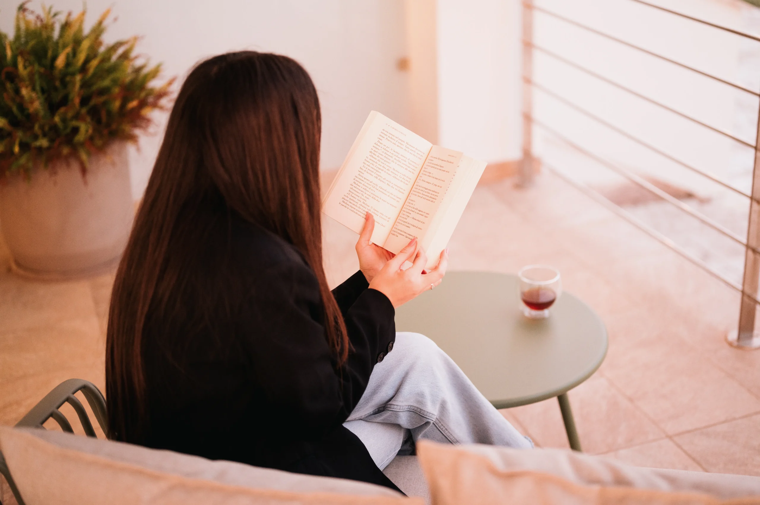 Ragazza che si rilassa leggendo un libro sul balcone della Suite